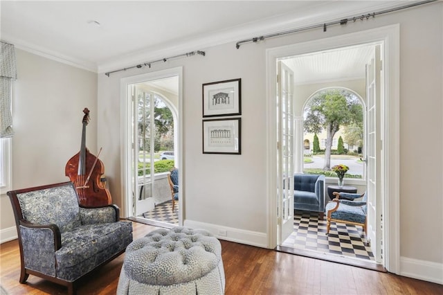 sitting room with dark hardwood / wood-style flooring and crown molding