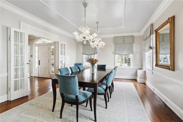 dining space with an inviting chandelier, crown molding, and hardwood / wood-style flooring