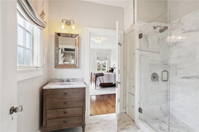 bathroom featuring hardwood / wood-style floors, walk in shower, and vanity