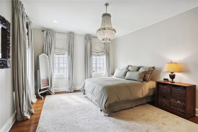 bedroom featuring an inviting chandelier and hardwood / wood-style floors