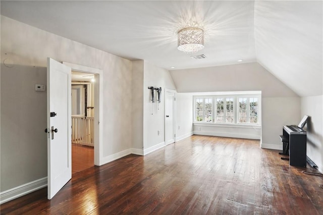 interior space featuring vaulted ceiling and dark hardwood / wood-style flooring