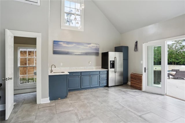 kitchen featuring high vaulted ceiling, sink, stainless steel fridge with ice dispenser, and a healthy amount of sunlight