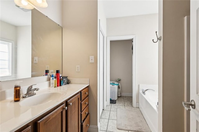 bathroom with tile patterned floors, a bathtub, and vanity