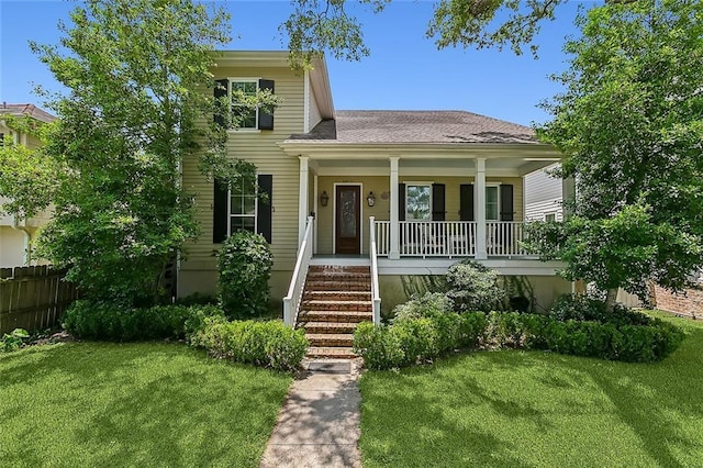 view of front facade featuring covered porch, stairway, and a front yard