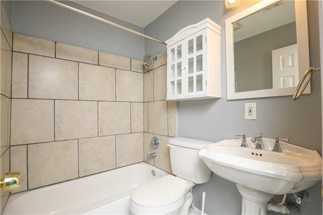 full bathroom with toilet, tiled shower / bath, and sink