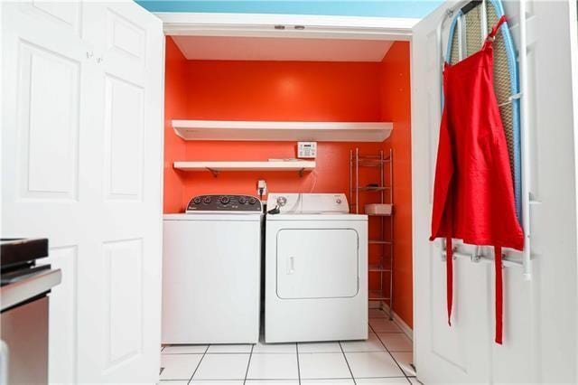 washroom with light tile patterned floors and washing machine and clothes dryer