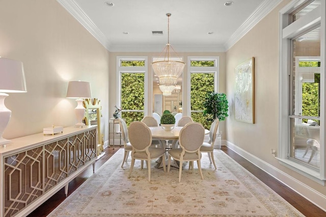 dining area with a chandelier, hardwood / wood-style floors, and crown molding