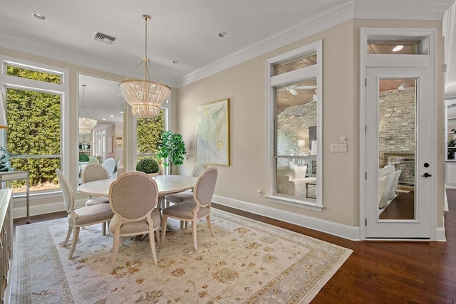 dining space with ornamental molding, dark wood-type flooring, a wealth of natural light, and a chandelier