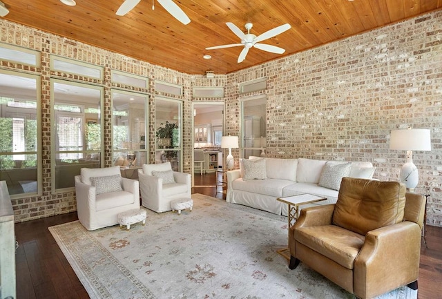 unfurnished living room featuring dark hardwood / wood-style flooring, ceiling fan, wooden ceiling, and brick wall