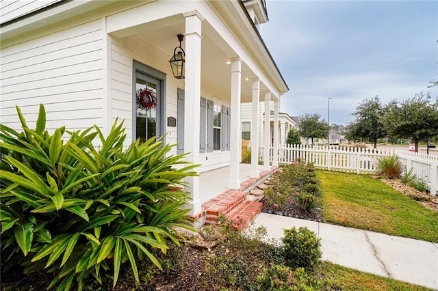 doorway to property with a yard and a porch