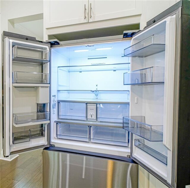 kitchen featuring fridge, white cabinets, and dark hardwood / wood-style flooring