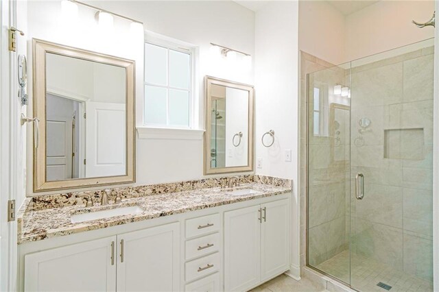 bathroom with a shower with door and vanity