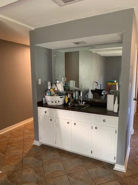 kitchen featuring white cabinetry and sink