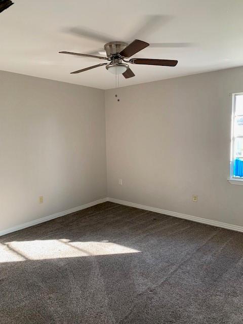 unfurnished room featuring ceiling fan and dark colored carpet