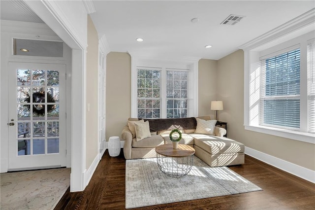 living room featuring visible vents, crown molding, baseboards, and wood finished floors