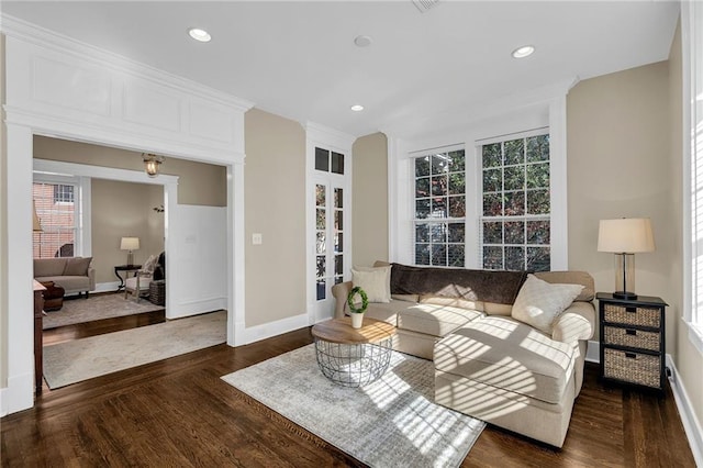 living area with baseboards, wood finished floors, and recessed lighting