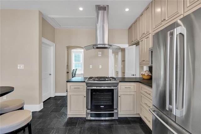 kitchen with stainless steel appliances, dark countertops, island range hood, a peninsula, and baseboards