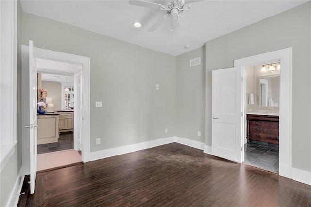 unfurnished bedroom featuring baseboards, visible vents, and dark wood-style flooring