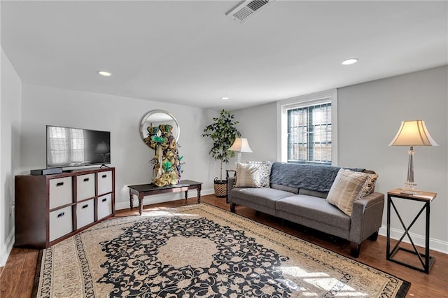 living area featuring recessed lighting, visible vents, baseboards, and wood finished floors