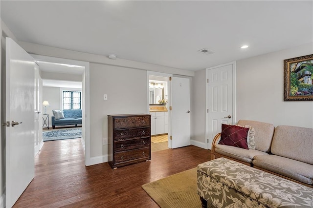 living area with dark wood-style floors, recessed lighting, visible vents, and baseboards