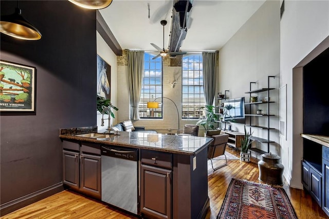 kitchen with a ceiling fan, tile countertops, a peninsula, light wood-type flooring, and stainless steel dishwasher