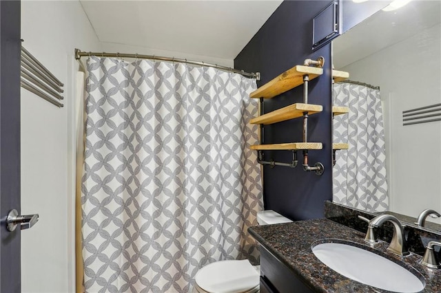 bathroom featuring a shower with shower curtain, vanity, and toilet