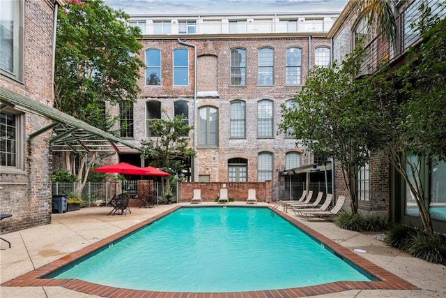 pool with a patio and fence