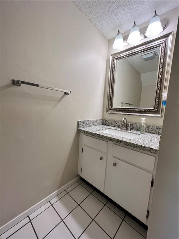 bathroom featuring vanity, tile patterned flooring, and a textured ceiling