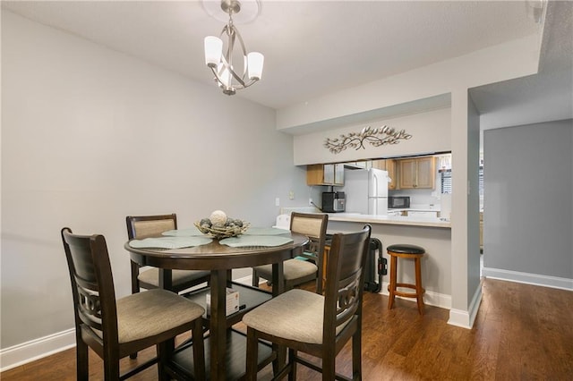 dining room with dark hardwood / wood-style floors and an inviting chandelier