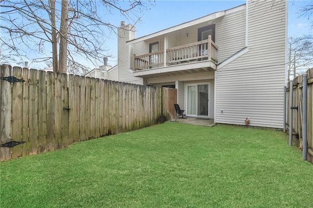 back of property with a lawn and a balcony