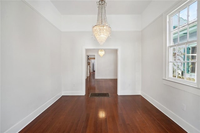 unfurnished dining area featuring a notable chandelier, dark hardwood / wood-style floors, and plenty of natural light