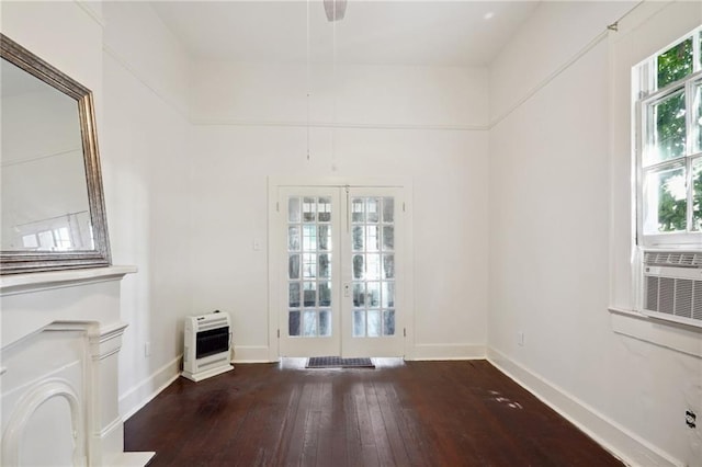 unfurnished living room featuring french doors, heating unit, and hardwood / wood-style flooring