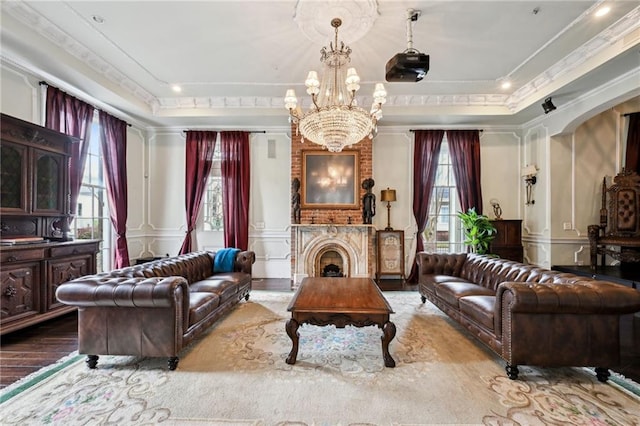 living room with light wood-type flooring, a raised ceiling, a notable chandelier, and a wealth of natural light