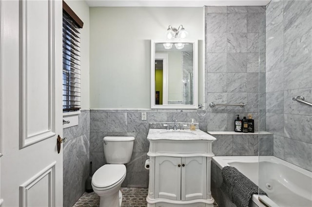 bathroom with tile patterned flooring, toilet, vanity, tile walls, and a bathtub