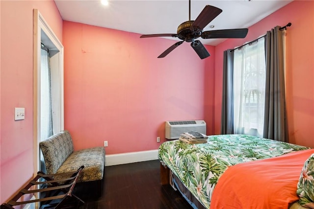 bedroom featuring ceiling fan, dark hardwood / wood-style flooring, and a wall unit AC