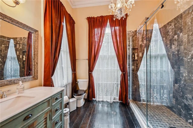 bathroom with a chandelier, wood-type flooring, toilet, crown molding, and an enclosed shower