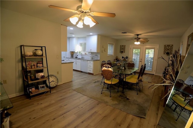 dining area with a healthy amount of sunlight, french doors, light hardwood / wood-style floors, and sink