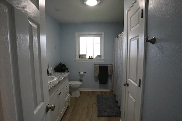 bathroom featuring toilet, vanity, and hardwood / wood-style flooring