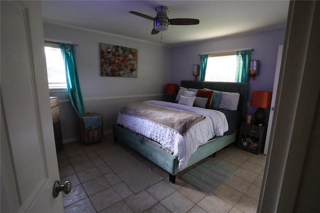 tiled bedroom with ceiling fan and ornamental molding