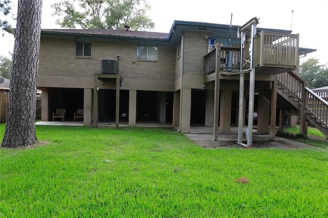 rear view of property featuring central AC unit, a patio area, a yard, and a deck