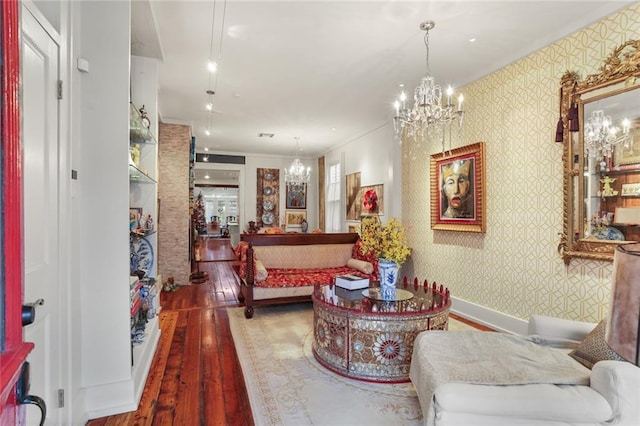 living room featuring crown molding, an inviting chandelier, and hardwood / wood-style flooring