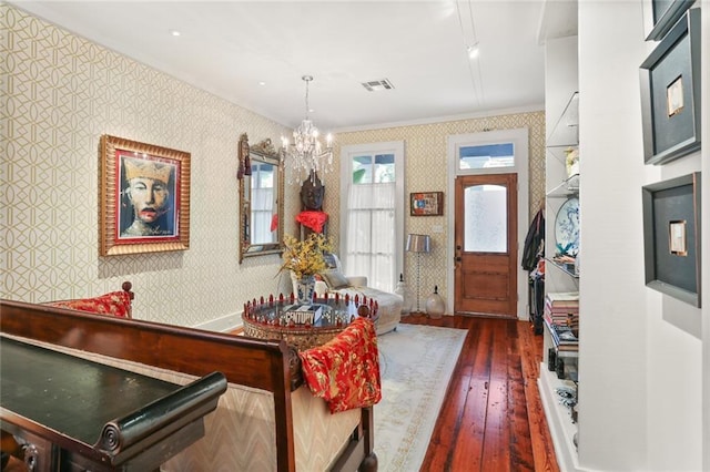 interior space with dark hardwood / wood-style flooring, an inviting chandelier, and crown molding