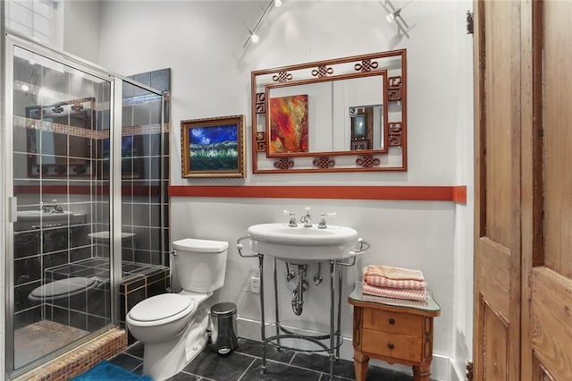 bathroom with toilet, tile patterned floors, a shower with shower door, and sink