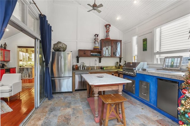 kitchen featuring sink, vaulted ceiling, ceiling fan, wood ceiling, and stainless steel appliances