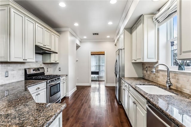 kitchen featuring sink, stainless steel appliances, dark hardwood / wood-style flooring, dark stone counters, and white cabinets