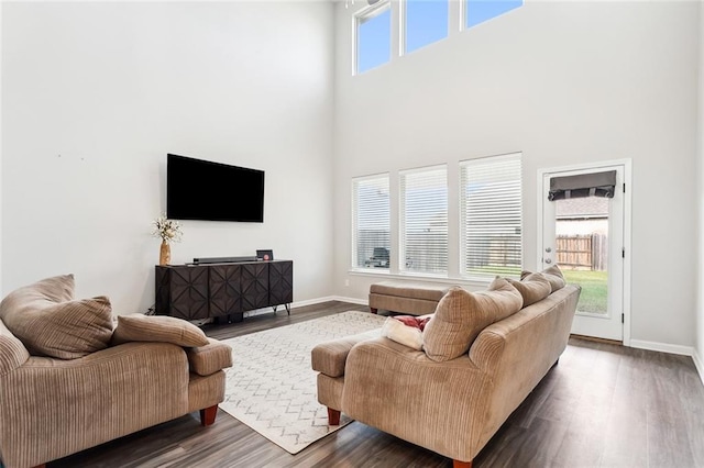 living room with dark hardwood / wood-style flooring and a towering ceiling