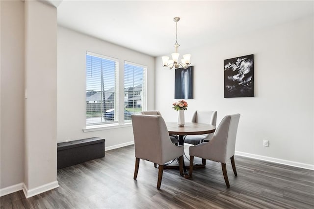 dining room with dark wood-type flooring and a notable chandelier