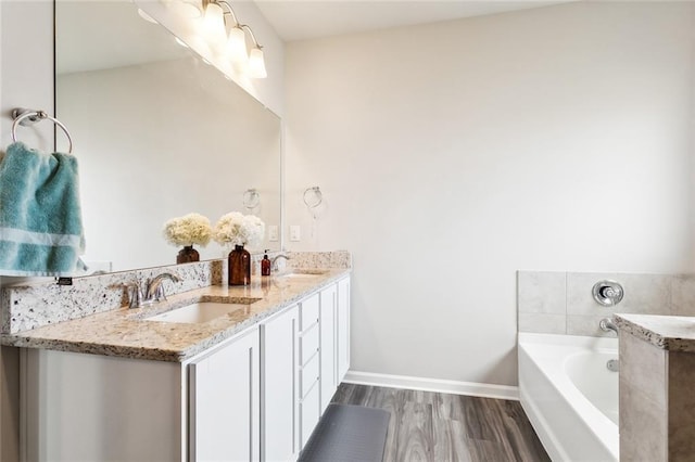 bathroom with hardwood / wood-style floors, vanity, and a bathtub