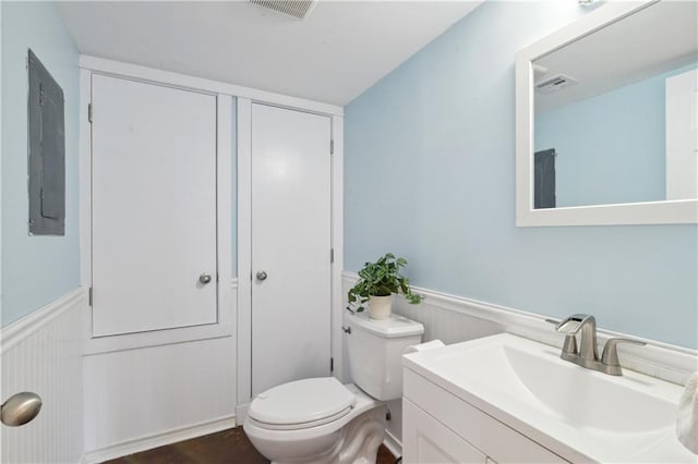 bathroom with vanity, toilet, and electric panel