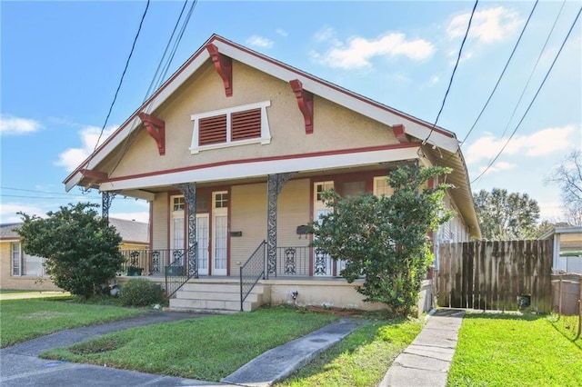 bungalow featuring a porch and a front lawn